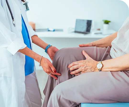 Especialista revisando la rodilla de una paciente en consulta